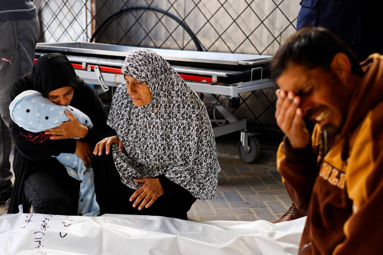 Avó (meio) e outros familiares do bebê Idres Al-Dbari, morto na Faixa de Gaza