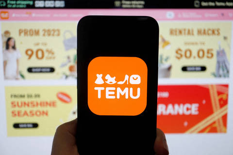 FILE PHOTO: The logo of Temu, an e-commerce platform owned by PDD Holdings, is seen on a mobile phone displayed in front of its website, in this illustration picture taken April 26, 2023. REUTERS/Florence Lo/Illustration/File Photo ORG XMIT: FW1