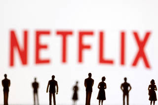FILE PHOTO: Toy figures of people are seen in front of the displayed Netflix logo, in this illustration