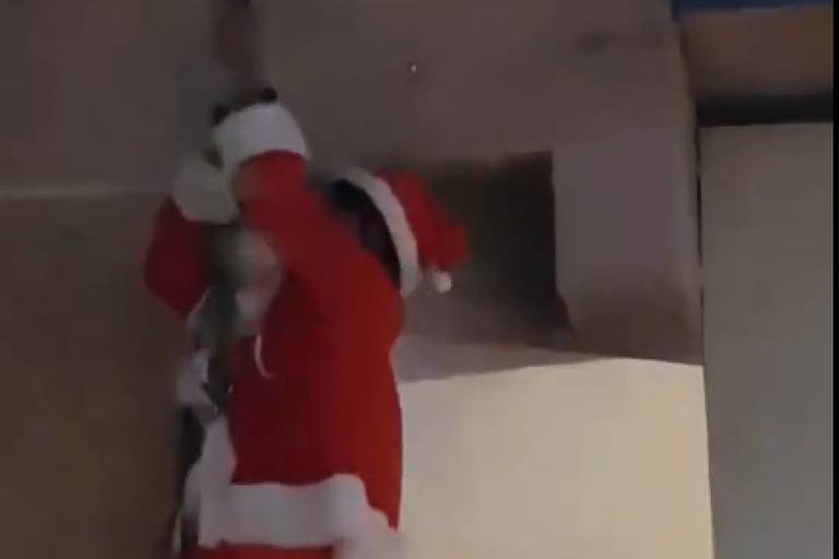 Papai Noel chega de rapel, enrosca barba e fica pendurado, em MG