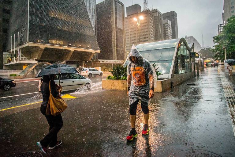 Pessoas andam na chuva em São Paulo