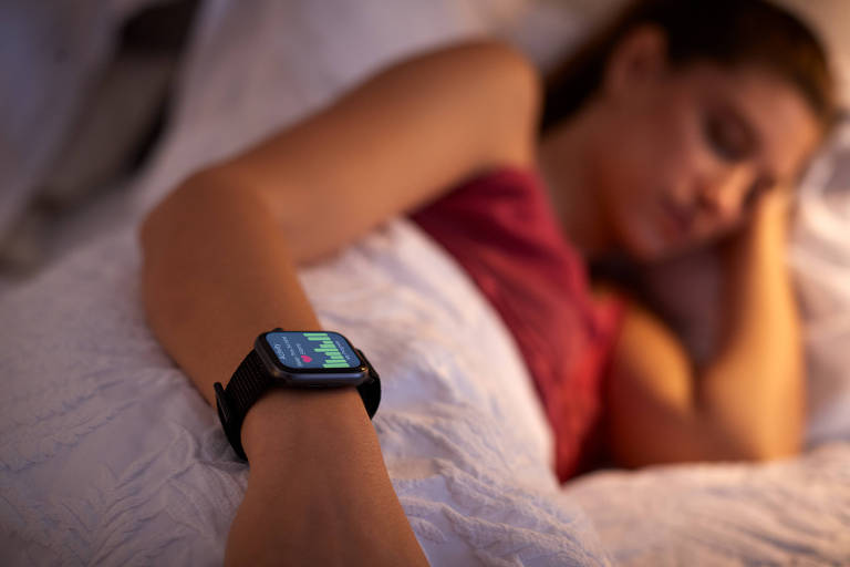 Fotografia de uma mulher branca dormindo com um relógio no pulso