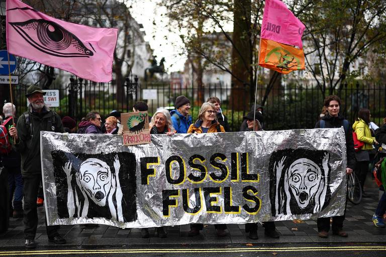 Idosos seguram cartaz que diz 'fossil fuels' (combustíveis fósseis) feito com material prateado; ao lado do escrito há duas ilustrações de um rosto gritando, semelhantes ao famoso quadro 'O Grito', de Edvard Munch