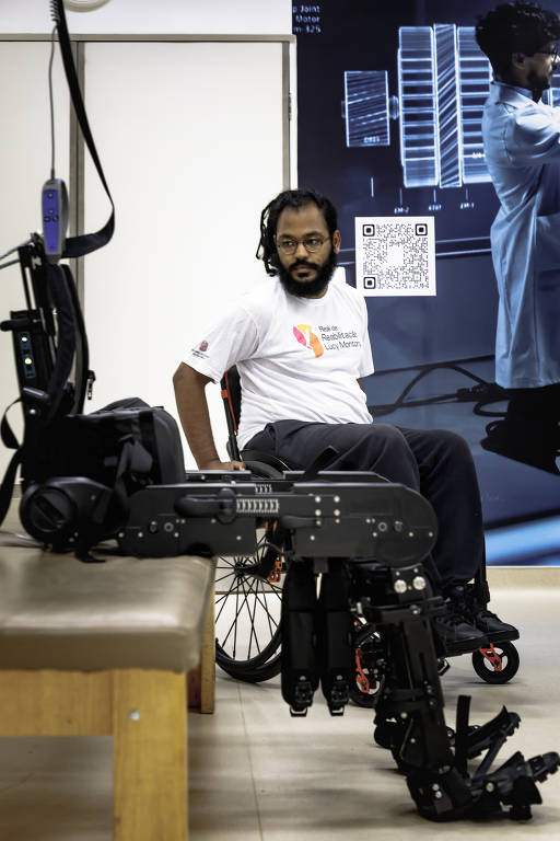 Levi Silva Castro, 25, observa o exoesqueleto ExoAtlet