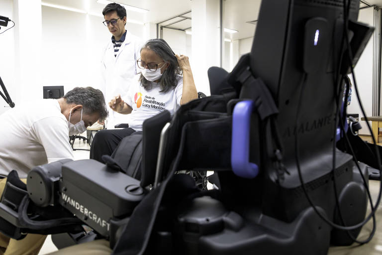 Luiz Gonzaga Pereira de Souza Filho, 73, ajuda a esposa, Helena Torres Souza, a se posicionar para o início do exercício