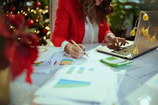 Business owner woman in green office with Christmas tree working