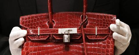 (FILES) This photo taken on June 21, 2007, shows an employee holding a 129,000 USD crocodile Hermes Birkin Bag during a private opening for the new Hermes store on Wall Street in New York. At the end of May 2013, French auction house 'ArtCurial' claimed 