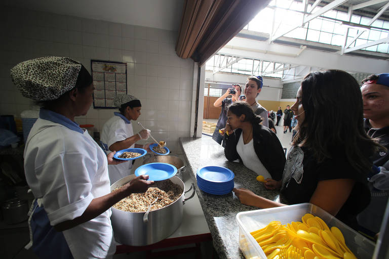 Merendeiras servem almoço para alunos em escola estadual