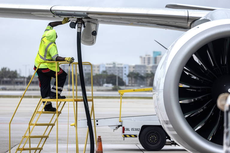 Trabalhador da Swissport abastece aeronave Embraer E195-E2 da Porter Airlines enquanto se prepara para partir do Aeroporto Internacional de Miami, nos EUA
