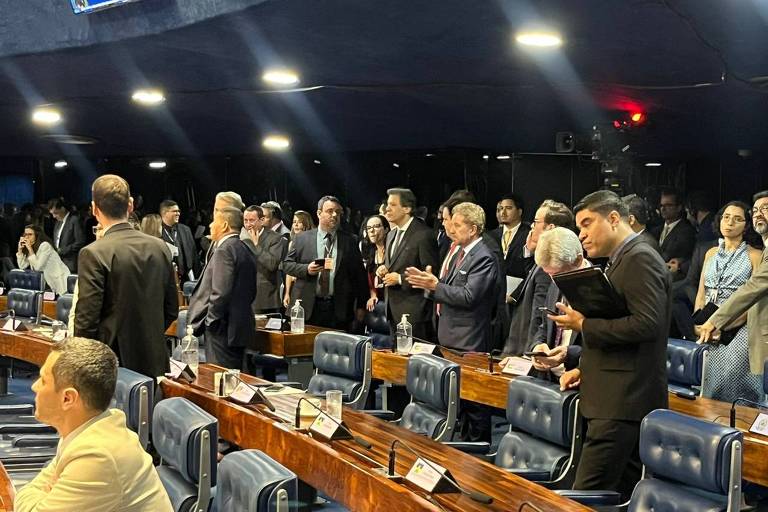 Fernando Haddad, de terno, é rodeado de senadores no plenário do Senado
