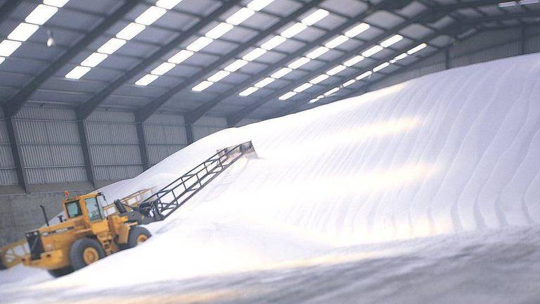 Máquina maneja toneladas de açúcar em uma fábrica