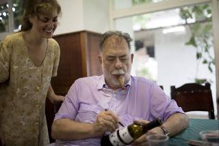 U.S. director Francis Ford Coppola signs an autograph on a bottle of wine for a student at the International School of Cinema and Television (EICTV) in San Antonio de los Banos, Cuba