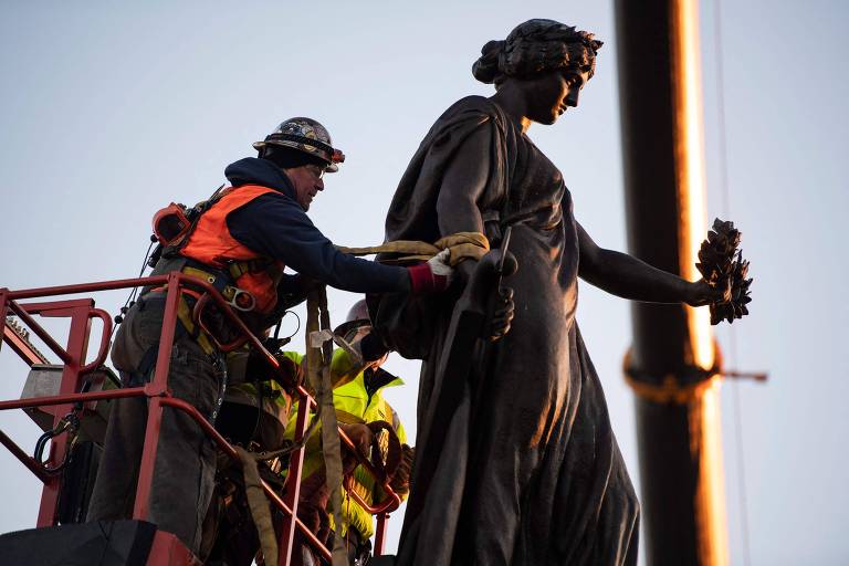 Trabalhador prepara remoção de estátua no cemitério de Arlington, no estado da Virgínia