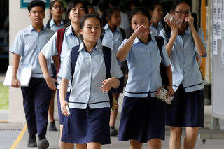 FILE PHOTO: Students leave for classes after their recess at a secondary school in Singapore