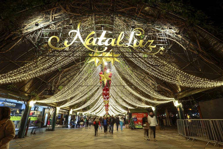 Pavilhão coberto por luzes e placa gigante acesa com 'Natal Luz' escrito.