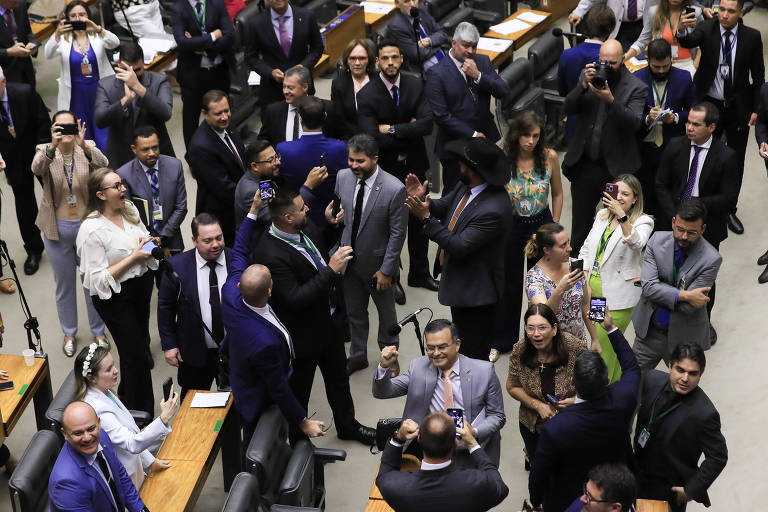 Imagem mostra parlamentares reunidos em plenário do Congresso. Eles estão de pé.