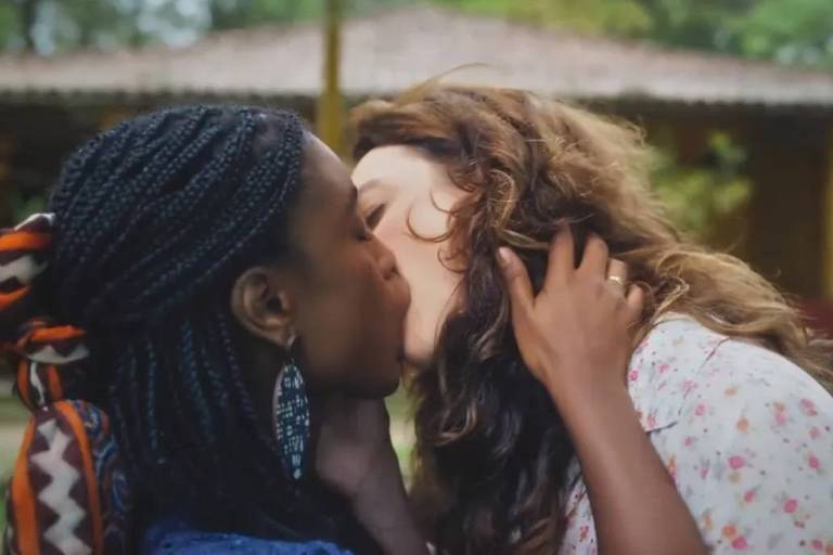 Em foto colorida, duas mulheres se beijam