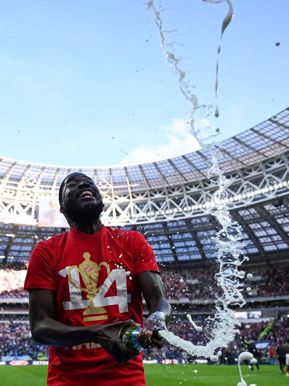 Usando uma camisa vermelha com o número 14 e estourando um espumante, Shamar Nicholson comemora a conquista da Copa da Rússia de 2022 pelo Spartak de Moscou no estádio Luzhniki