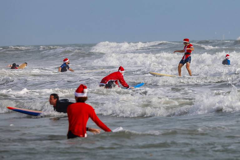 Competição reúne centenas de 'Papais Noéis surfistas' em praia da Flórida, nos EUA