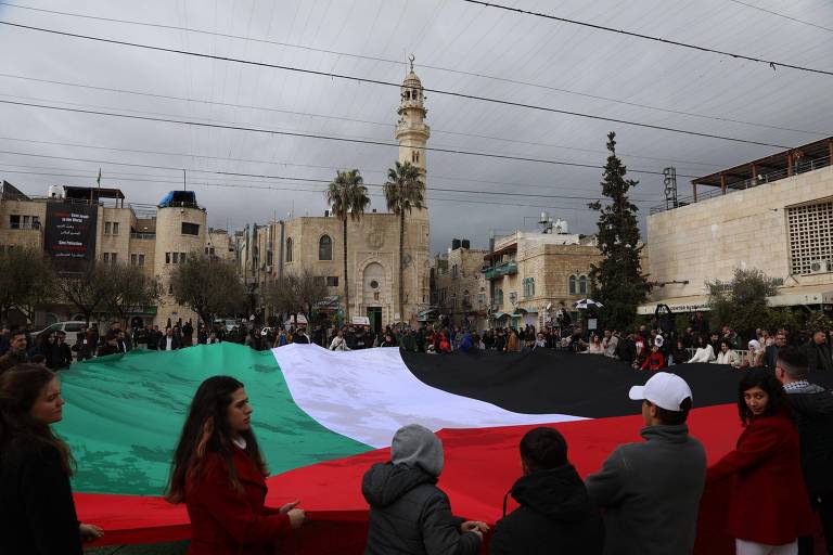 Manifestantes seguram bandeira da palestina