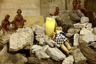 An installation of baby Jesus lying amidst the rubble in the Evangelical Lutheran Church in Bethlehem
