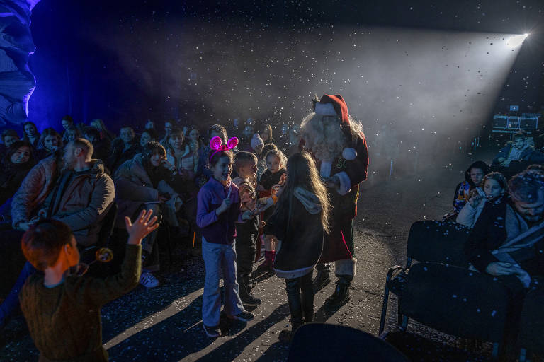 An actor dressed as Santa hands out gifts to children at a festival in Kyiv, Ukraine