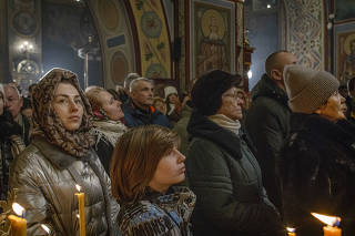 Ukrainians attend a Christmas Eve mass at St. Michael's Golden-Domed Monastery in Kyiv, on Dec. 24, 2023. (Laura Boushnak/The New York Times)