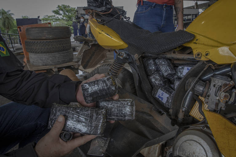 Fundo falso identificado em uma moto que tentava trazer anabolizantes para o Brasil; o motociclista foi preso e a passageira levada para a delegacia