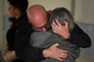 Sharon Avigdori, who was abducted by Hamas gunmen during the October 7 attack on Israel, hugs her husband Chen shortly after being released