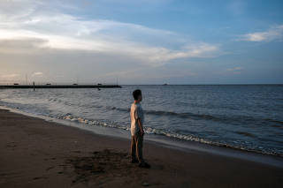 Neo Lu on a beach at an undisclosed location in September 2023. (Adriana Loureiro Fernandez/The New York Times)