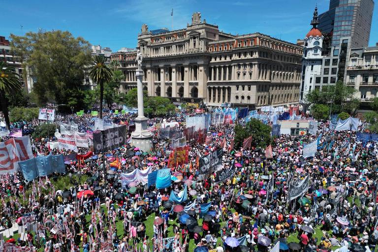Multidão de pessoas, muitas vestidas de azul e branco, se aglomeram em frente a Palácio da Justiça na Argentina