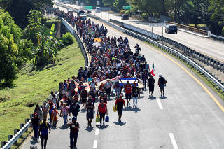 Migrants walk in a caravan to reach the U.S. border through Mexico, in Huixtla