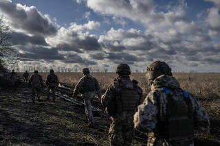 Ukrainian servicemen walk at a position near the front line town of Marinka