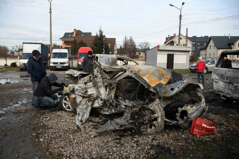 Ucranianos inspecionam carro destruído durante ataque aéreo russo na capital, Kiev