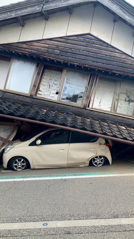 Carro fica preso sob casa após terremoto atingir cidade de Shika, na província de Ishikawa, no Japão
