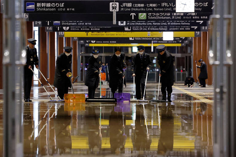 Funcionários de estação ferroviária em Kanazawa, no Japão, tentam remover água do local após inundação causada por terremoto