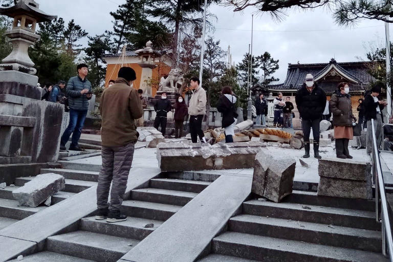Visitantes do Templo Onohiyoshi, em Kanazawa, província de Ishikawa, no Japão, observam tradicional portão torii que desabou após terremoto