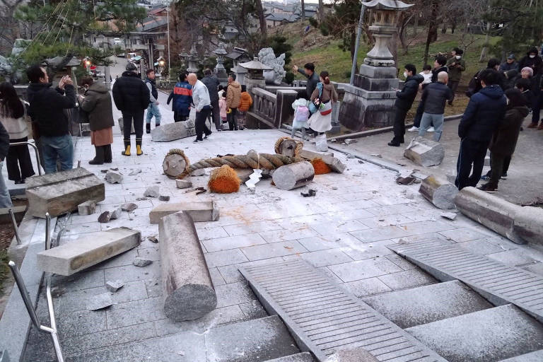 Visitantes do Templo Onohiyoshi, em Kanazawa, província de Ishikawa, no Japão, observam tradicional portão torii que desabou após terremoto