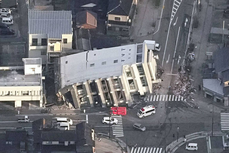 Imagem aérea mostra edifício desabado por causa do terremoto em meio ao cenário urbano.