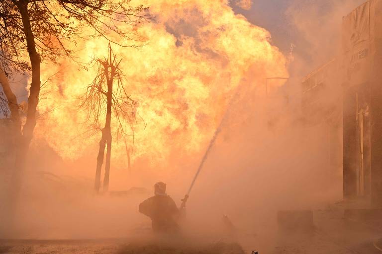 Bombeiros ucranianos tentam apagar incêndio após ataque de míssil em Kiev