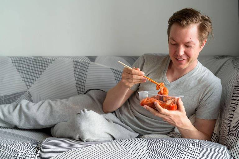 homem comendo kimchi na cama