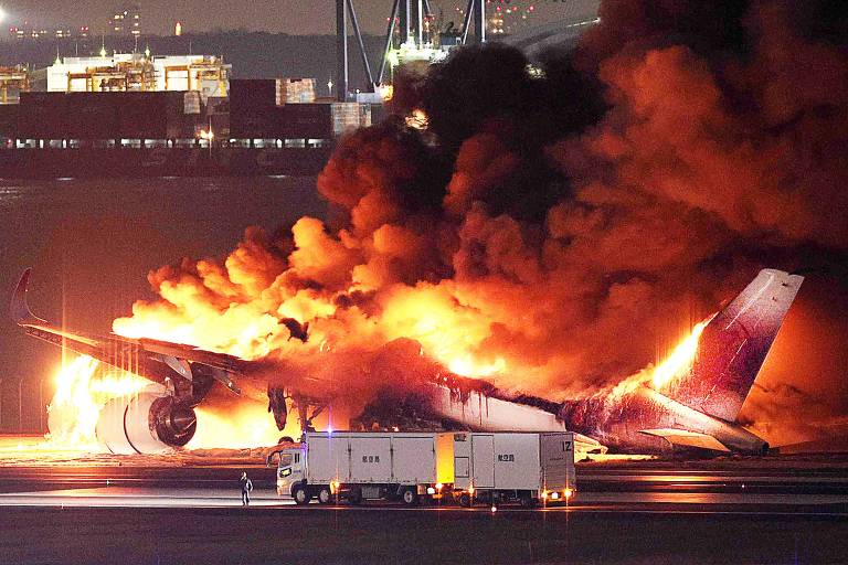 Avião em chamas em uma das pistas do aeroporto de Haneda, em Tóquio, após colidir com aeronave da guarda costeira