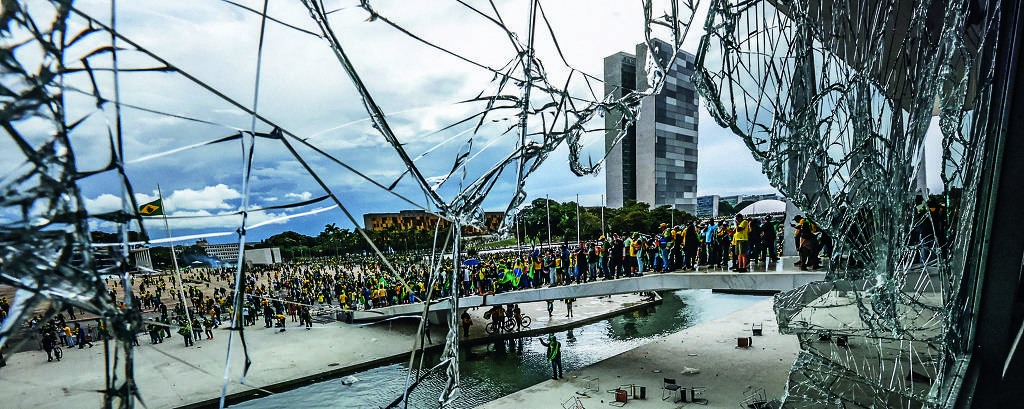Vândalos invandem a praça dos Três Poderes e depredam os prédios; na imagem, vidraça do Palácio do Planalto quebrada