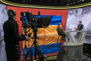 Oleksiy Dmytrashkivskiy, head of public relations for the Ukrainian army, is interviewed by Telemarathon host Vadym Karpiak in Kyiv, Ukraine, Dec. 15, 2023. (Brendan Hoffman/The New York Times)