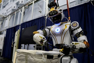 NASA's humanoid robot Valkyrie opens a bag at the Johnson Space Center in Houston