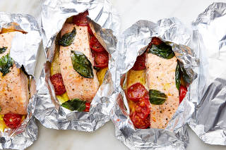 Salmon and tomatoes in foil. Food styled by Simon Andrews. (Linda Xiao/The New York Times)