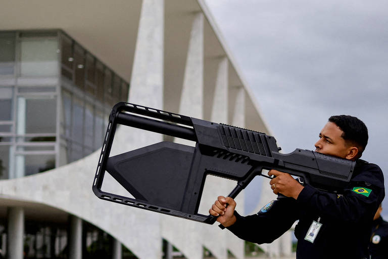Agente da Guarda Nacional usa uma arma anti-drone em ato de um ano de aniversário dos ataques de 8 de janeiro, em Brasília