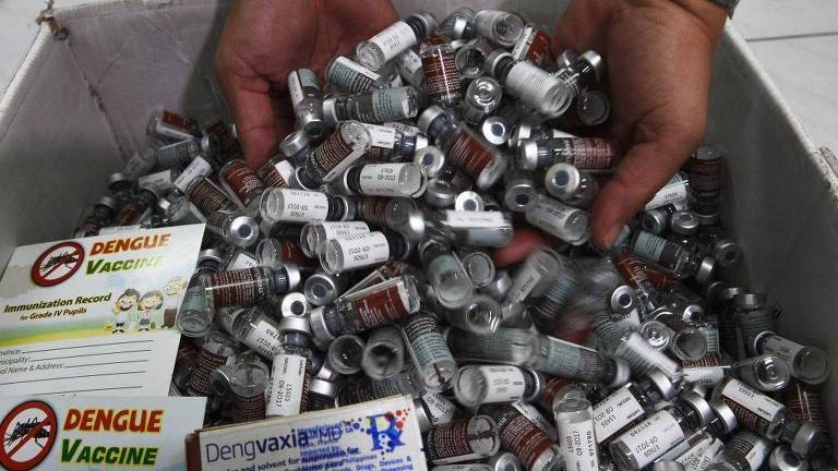Um profissional de saúde exige frascos usados da vacina contra dengue da Sanofi, Dengvaxia