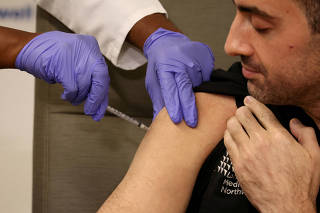 FILE PHOTO: Health workers receive the updated coronavirus disease (COVID-19) vaccine in New York