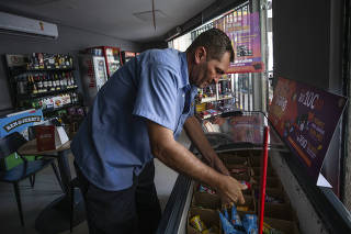 Chuvas em Sao Paulo, rescaldo: Erico Edgar da Silva, gerente do posto Ipiranga na Alameda Campinas (bairro Jd Paulistano) verifica sorvetes derretidos da loja de  conveniencia por falta de energia eletrica